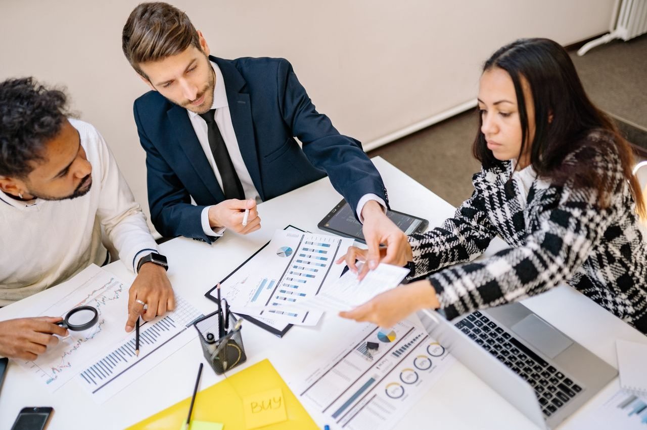 Business professionals engaging in a collaborative meeting with charts and documents.